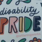 'Disability pride' sticker with pride in capital letters and the words surrounded by flowers