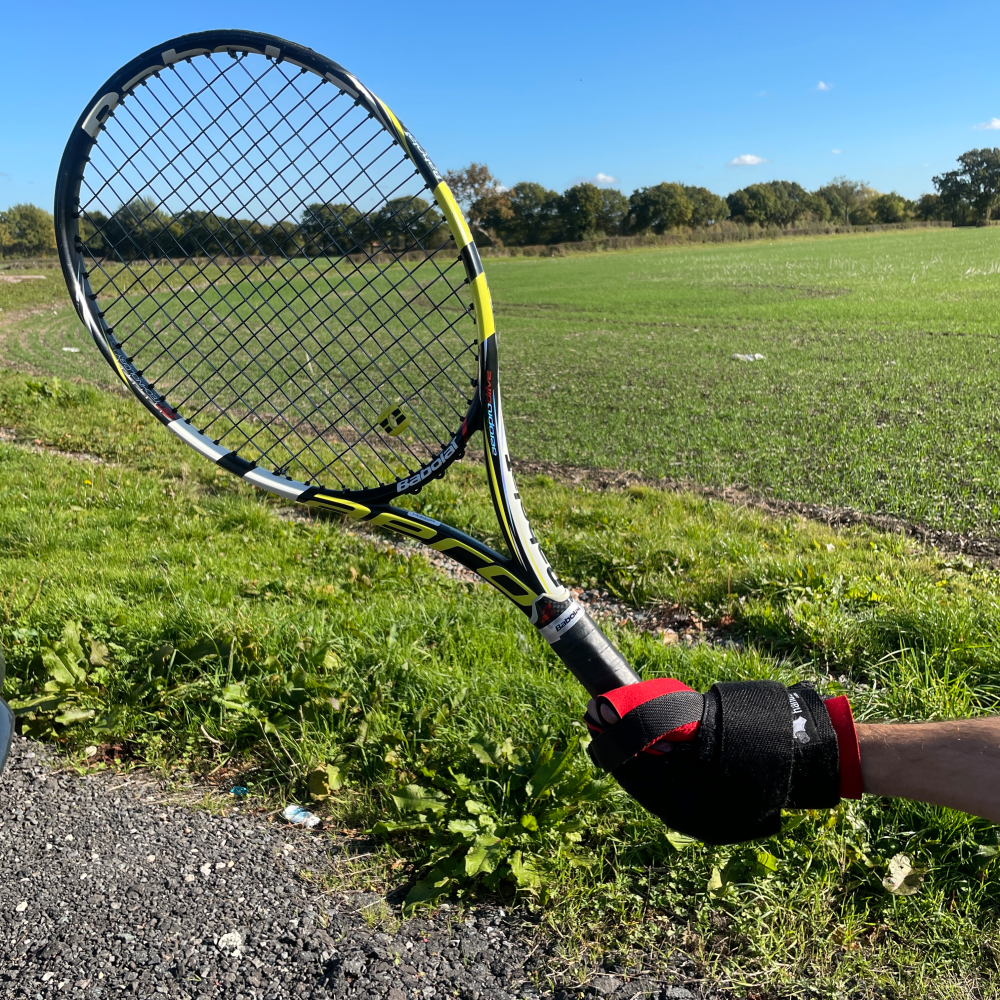 a tennis racket being held by the angled aid showing how it is held at a more natural angle