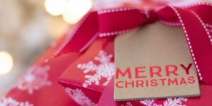 Christmas presents in red wrapping paper with snowflakes and a tag saying Merry Christmas