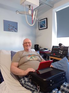 Mike in bed using a trabasack max lap tray to lean his tablet against