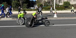 Rob mid-race in his racing wheelchair overtaking two other wheelchair racers