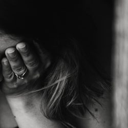 Black and white image of woman with her head in her hands