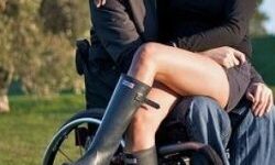 Woman sat in the lap of a man in a wheelchair
