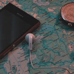 Smartphone laying on map with compass