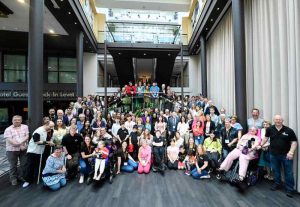 A large group of people pose for a photo in a hotel lobby. These are people attending the FOP conference.