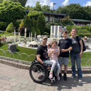 Rob, his wife and two children stand in front of the NASA models at the Legoland model village.