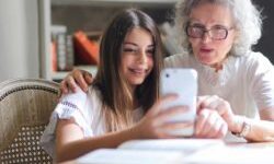 older woman showing something on her phone to younger girl (grand daughter?)