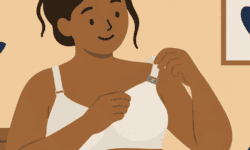 Disabled woman using one hand to adjust the clip on an adaptive nursing bra.